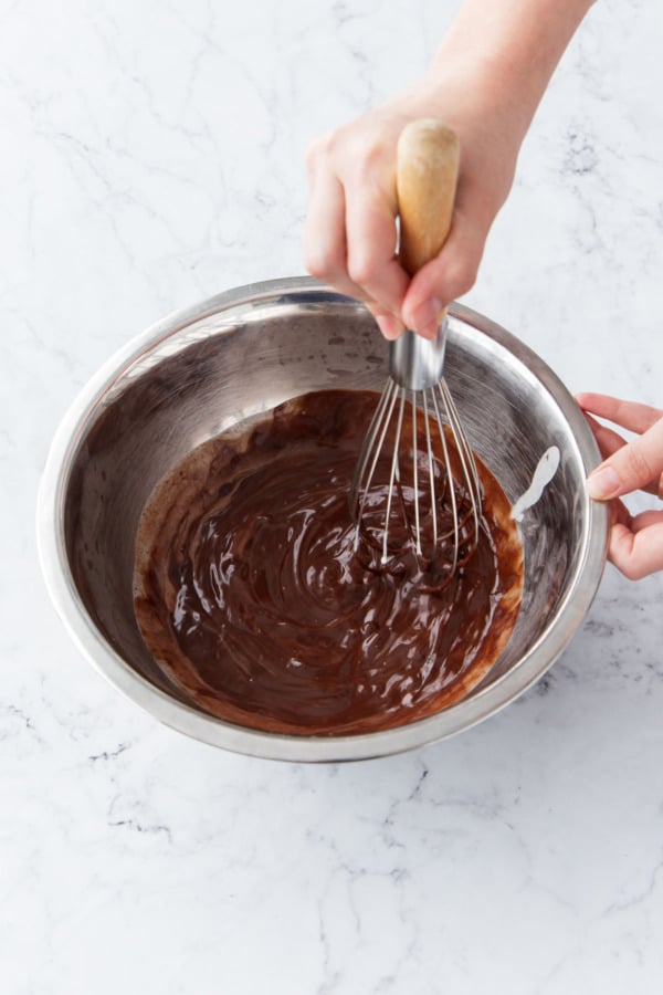 Whisking until the chocolate is fully melted and ganache is smooth.