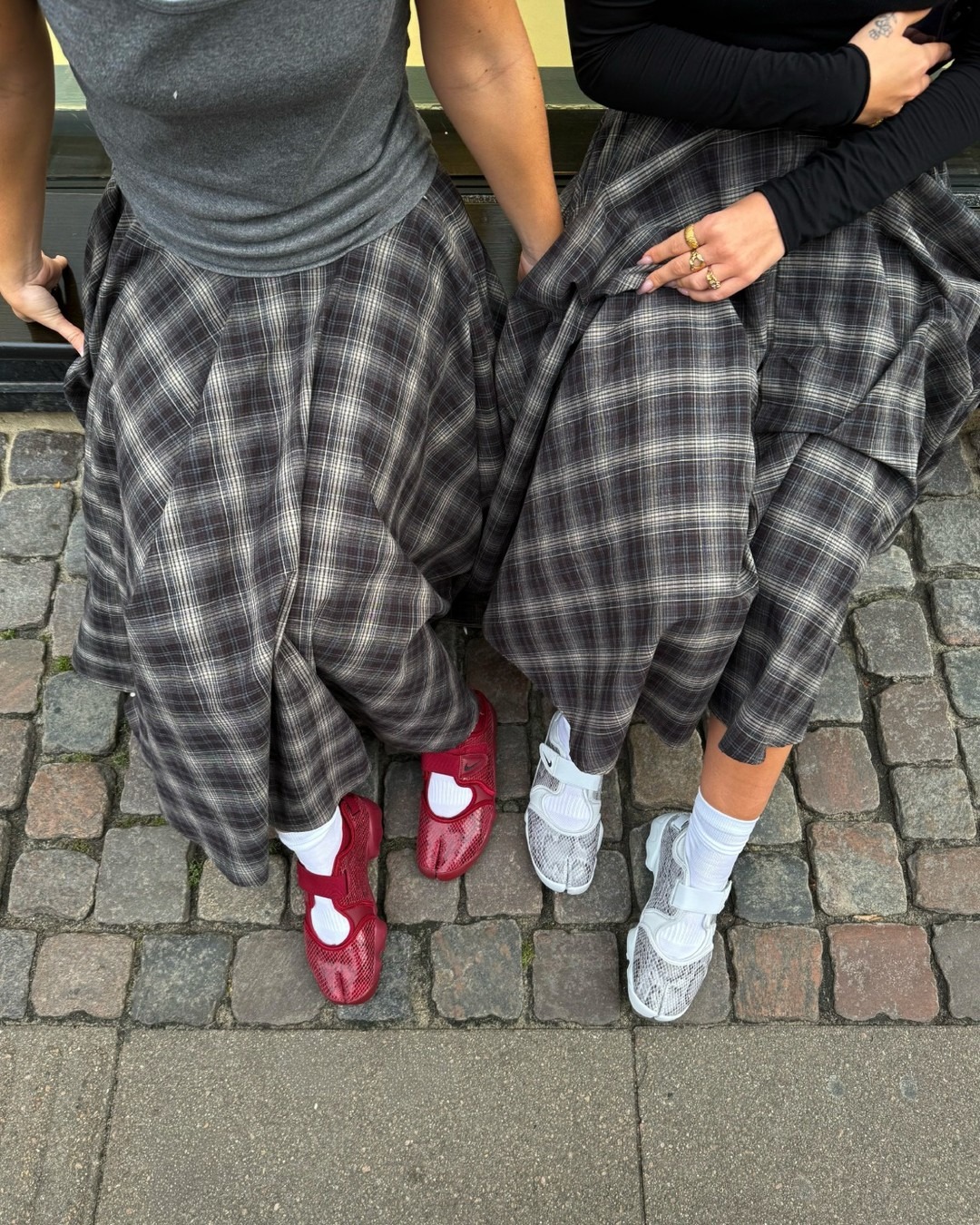 Influencers wears Nike Air Rift trainers with a checked skirt.