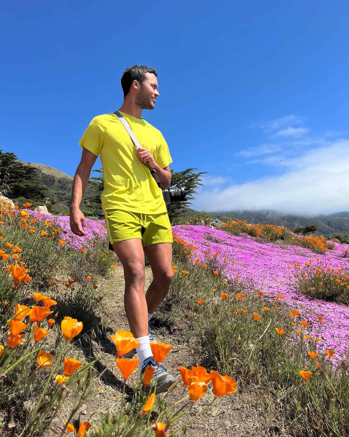 Man in flower field wearing bright yellow athleisure outfit
