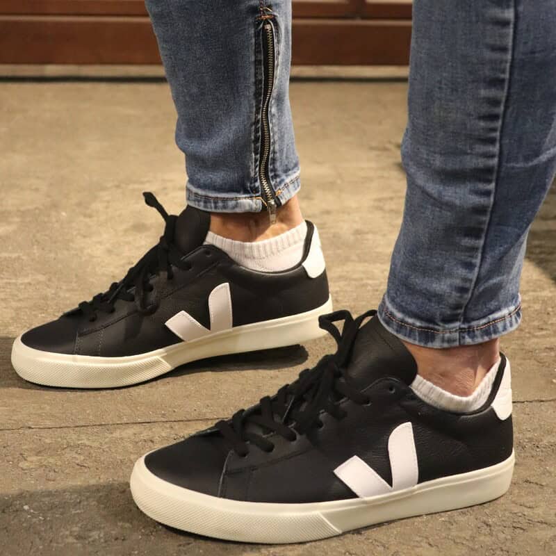 man wearing a black and white veja sneakers