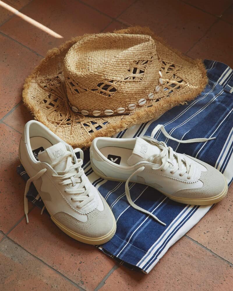 a pair of veja volly sneakers with a straw hat and striped shorts