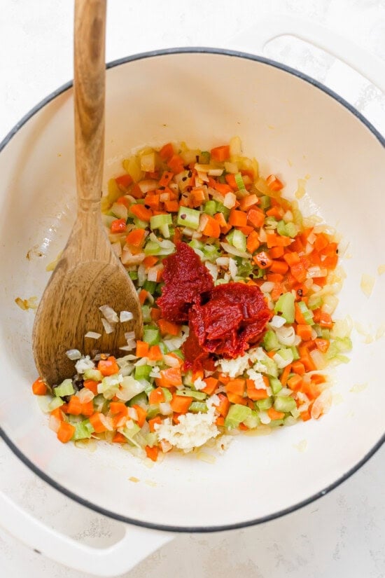 celery, carrots, onions and tomato paste in a pot