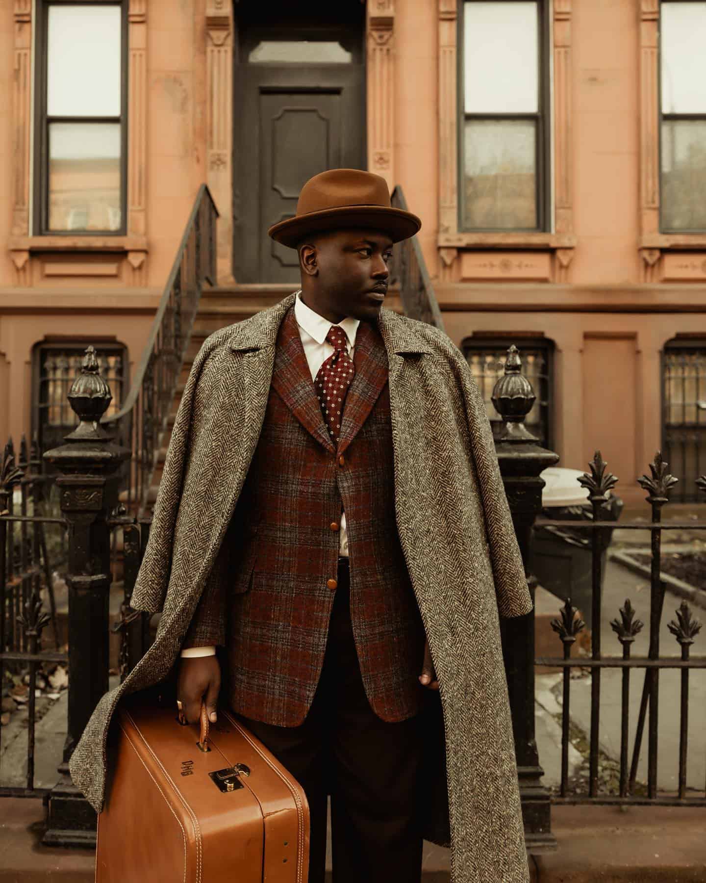 man in a suit layered with a long coat