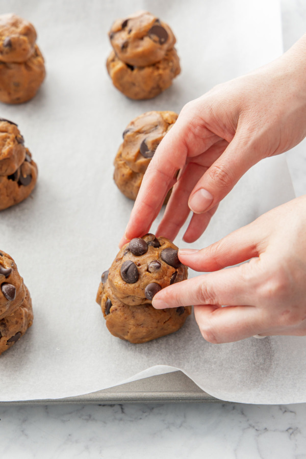 Stacking dough balls to form a little snowman shape.