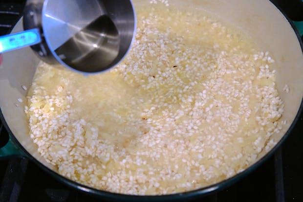 gradually adding liquids to saucepan