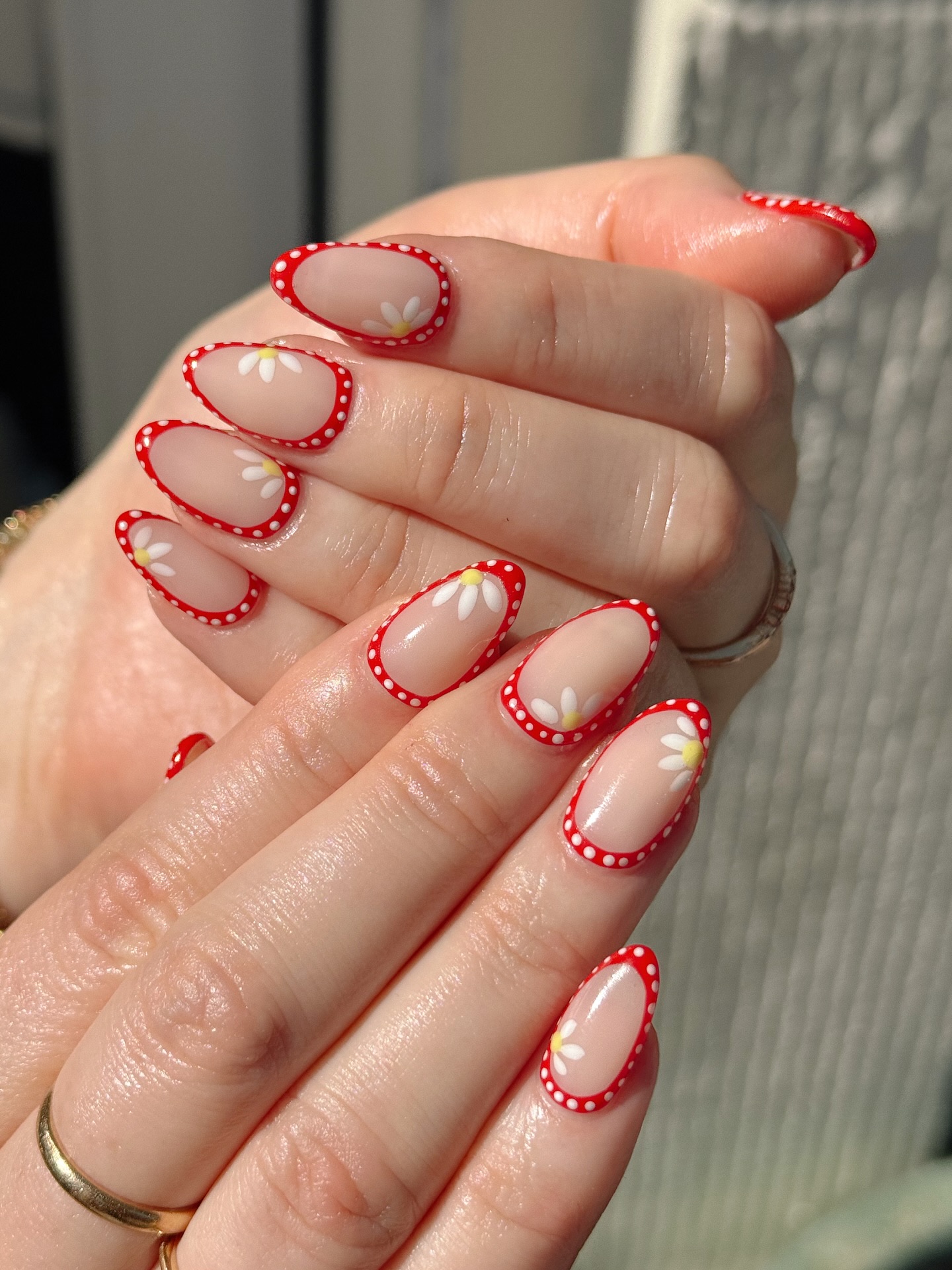 Red perimeter nail art with white polka dots and flowers.