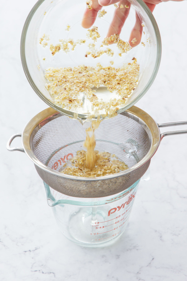 After steeping, strain the syrup through a fine mesh sieve to remove the flowers.
