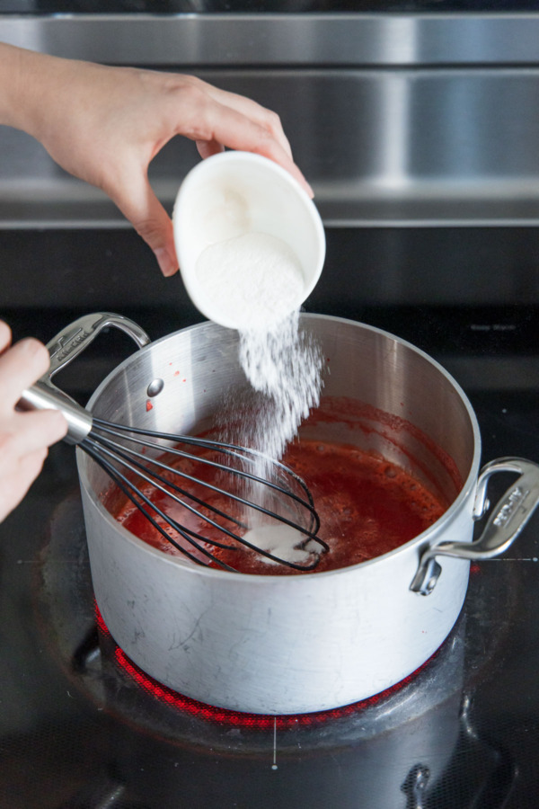 Whisking in powdered pectin into the strawberry juice.