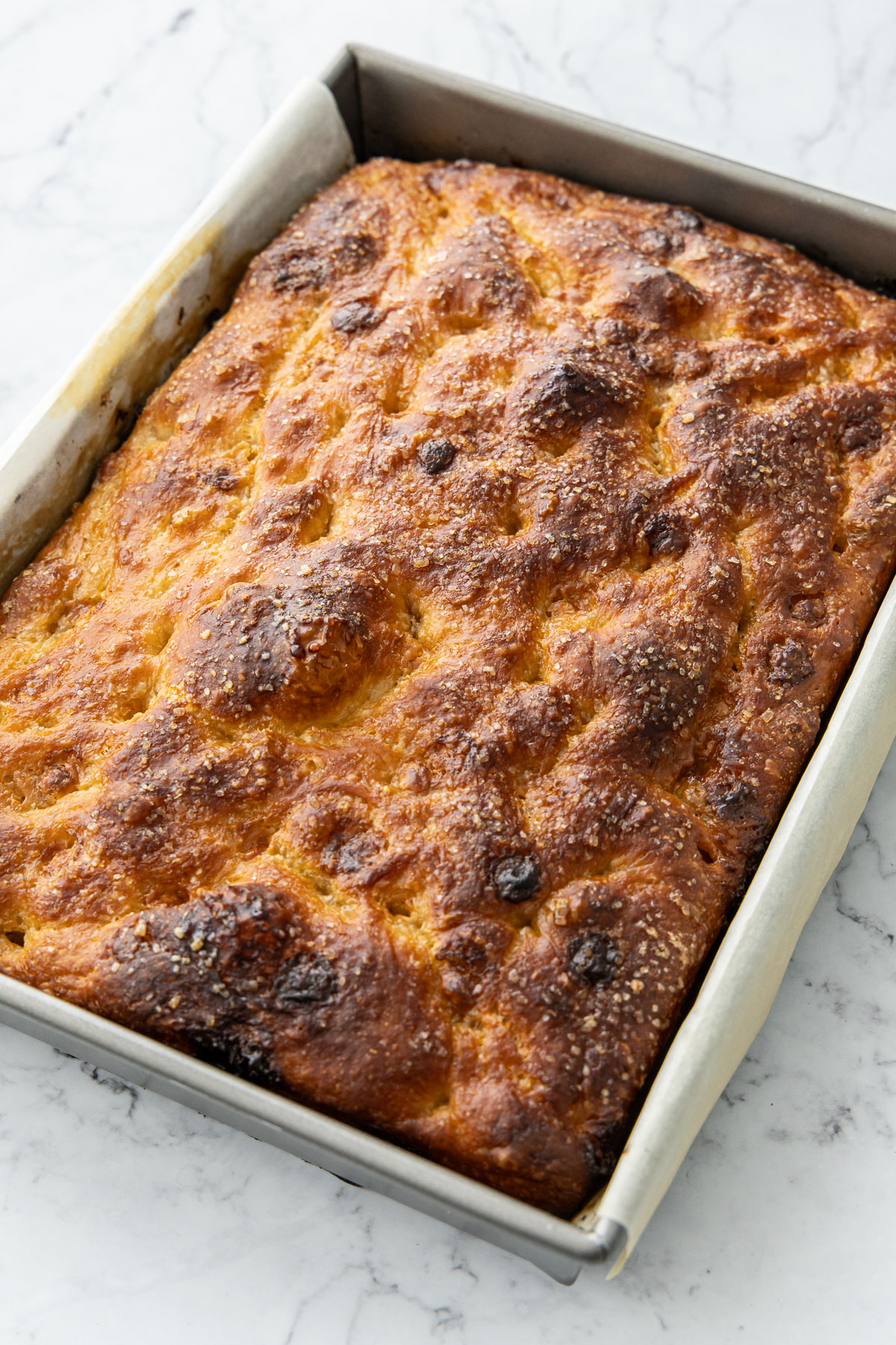 After baking, the top of the White Chocolate Focaccia Bread is deeply golden brown and bubbly.