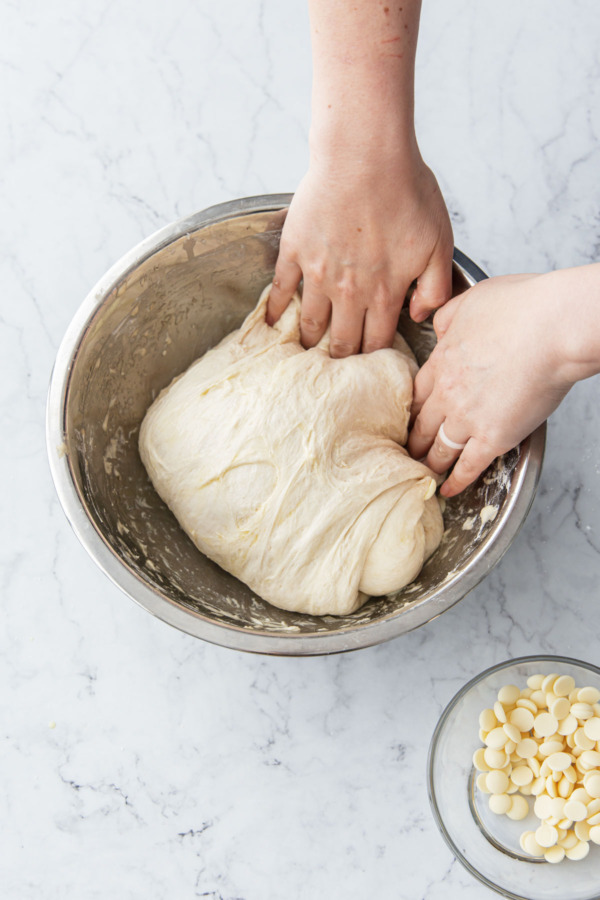 Folding the dough back over itself.