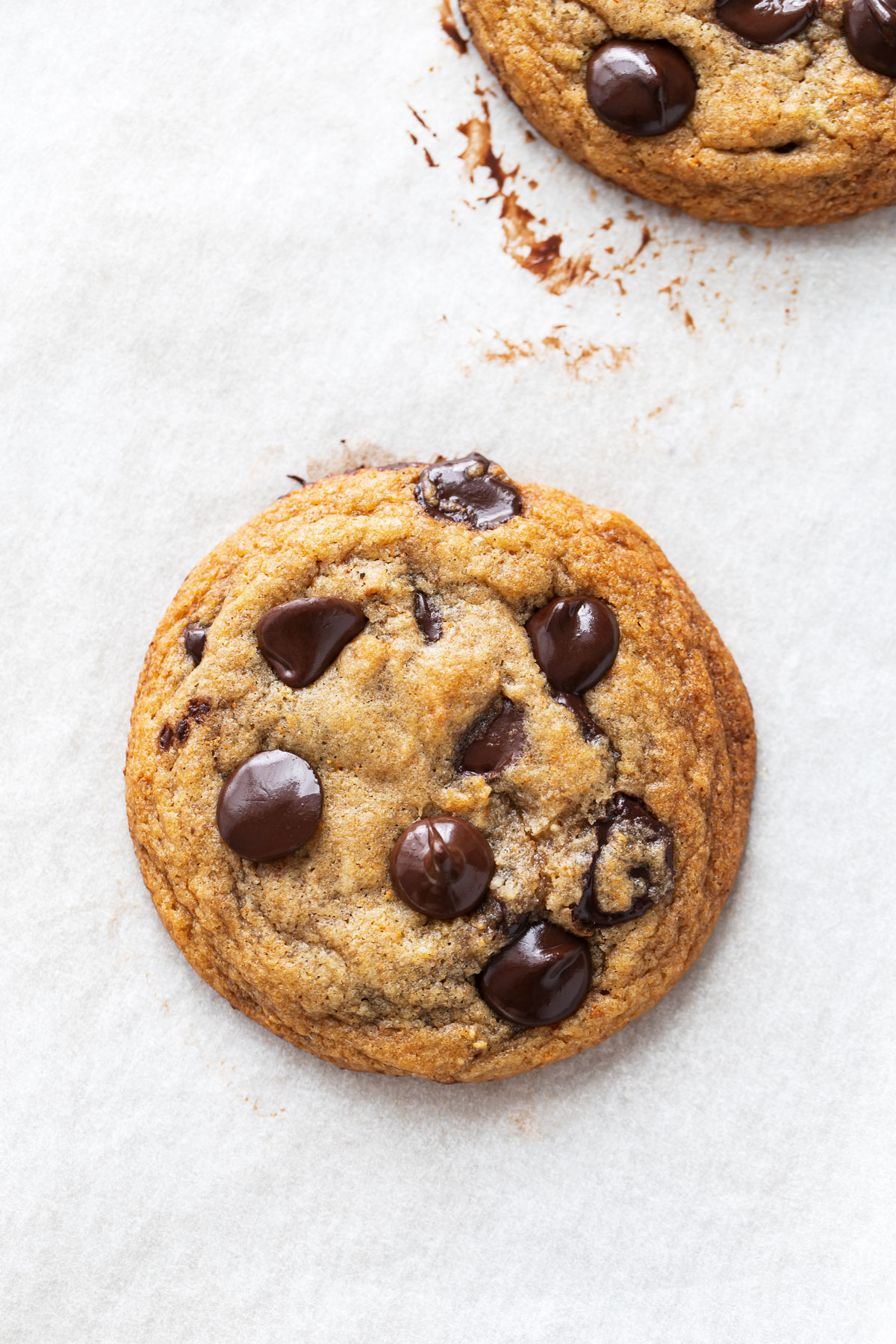 Closeup of a Brown Butter Banana Bread Chocolate Chip Cookie on a sheet pan after baking.